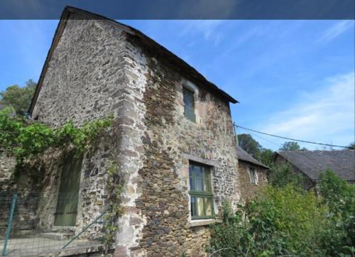 an old stone building with ivy growing on it at Le Malaval in Saint-Solve