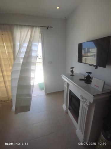 a living room with a fireplace and a flat screen tv at kelibia ezzahra plage a pied in Kelibia
