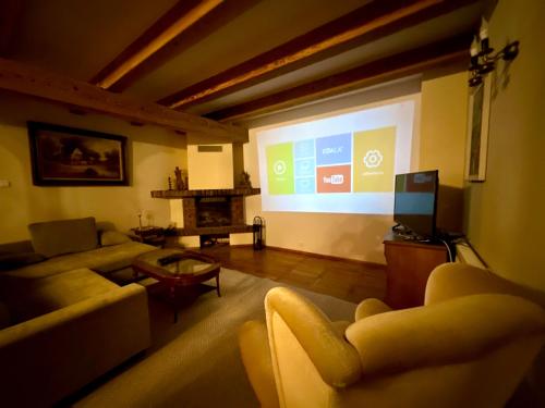 a living room with a large screen with a presentation at Dworek nad jeziorem z prywatną plażą in Krąg