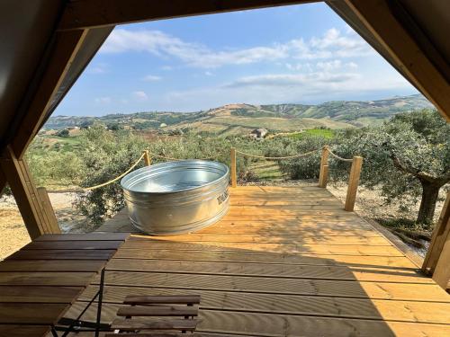 a large metal bucket sitting on top of a wooden deck at Glamping Uma Casanatura in Cellino Attanasio