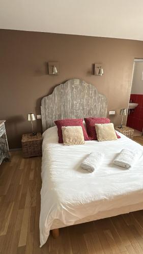 une chambre avec un grand lit blanc avec des oreillers rouges dans l'établissement chambres 
