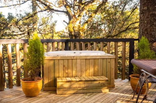 a wooden deck with a hot tub and a bench at Cascata dos Amores in Urubici