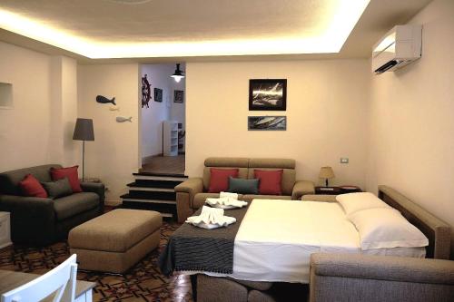a bedroom with a bed and a couch and chairs at La casa di Giacomo in Portovenere