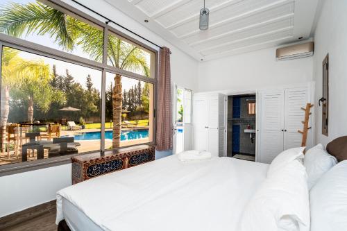 a bedroom with a bed and a large window at Chalet berbère 5 Chambres avec Piscine &Wifi fibre in Aït Imouni