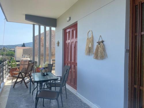 a patio with a table and chairs and a red door at Kouneli's House with Garden in Chios