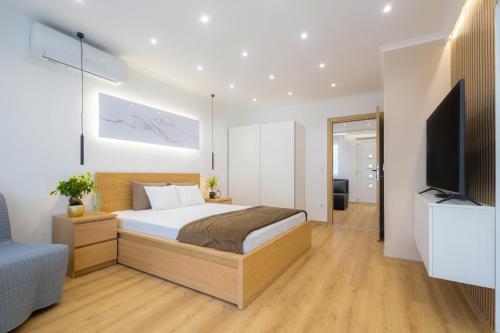 a bedroom with a bed and a flat screen tv at ÁbraApartman3 in Siófok
