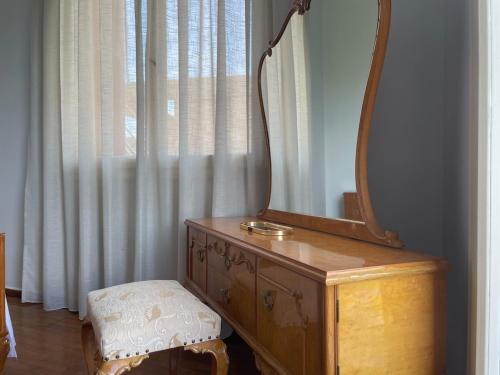 a mirror on top of a dresser next to a window at Kouneli's House with Garden in Chios