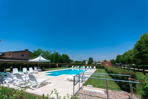 a swimming pool with lounge chairs and a swimming poolvisor at Agriturismo Al Buttasella in Lavariano