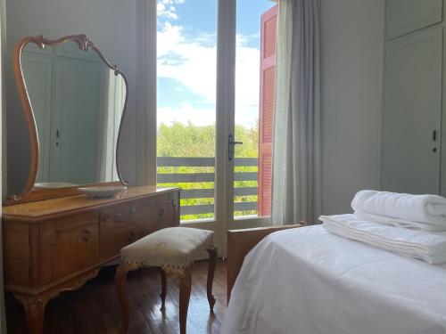a bedroom with a mirror and a bed and a dresser at Kouneli's House with Garden in Chios