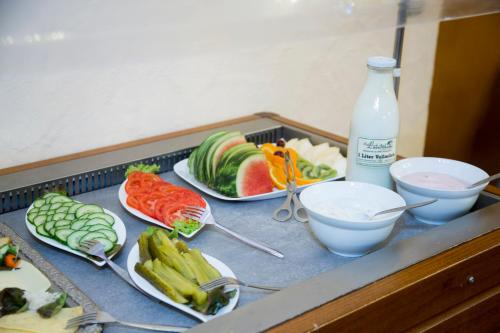 a counter with plates of food and a bottle of milk at Pension Ferienhof Fischer in Freiberg