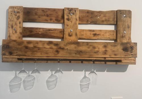 a wooden shelf with four white vases hanging from it at La casina di Stellatattoo in Crotone