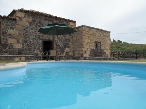 une grande piscine bleue en face d'un bâtiment dans l'établissement Casa Rural Vera De La Hoya, à San Miguel de Abona