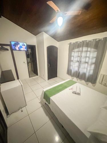 a bedroom with a bed and a ceiling fan at Pousada Villa das Palmeiras in Búzios