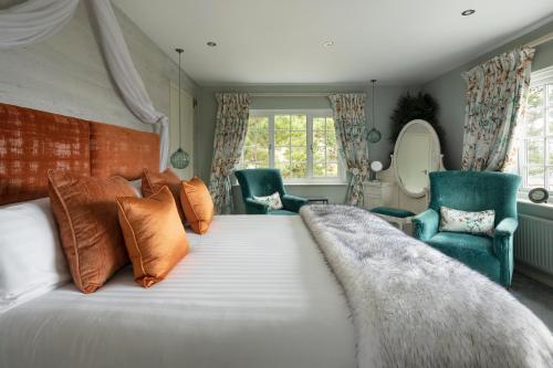 a bedroom with a large bed and two chairs at Talland Bay Hotel, Looe in Talland