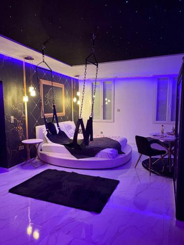 Cette chambre dispose d'un lit avec un éclairage violet. dans l'établissement Suite Secrète Love Room, à Callas