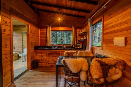 a dining room with a table and chairs in a cabin at Cascata dos Amores in Urubici