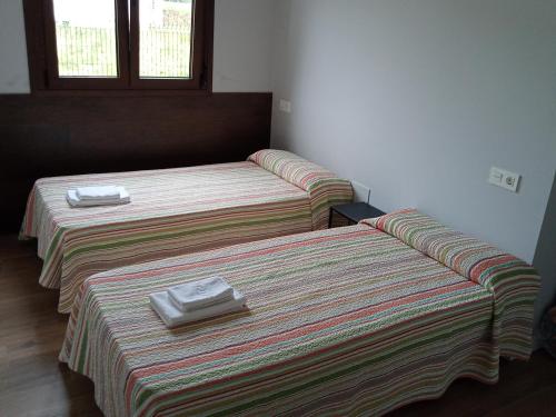 two beds in a room with towels on them at Casa Mariví in Niembro