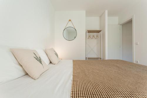 a bedroom with a large white bed with a mirror at Red Fox Lodge Serra da Estrela in Eirô