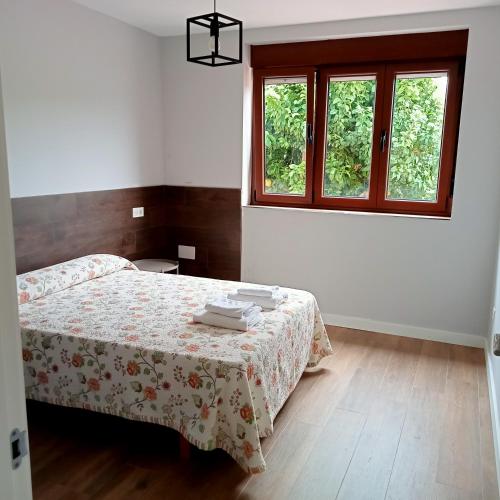 a bedroom with a bed and a window at Casa Mariví in Niembro