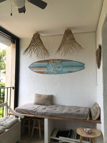 une planche de surf suspendue sur un mur à côté d'un banc dans l'établissement Breathtaking sea viewT3 for 6 pool parking, à Saint-Mandrier-sur-Mer