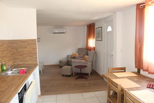 una cucina e un soggiorno con un divano e un tavolo di La Casette a Torreilles