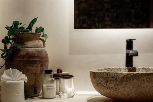 a bathroom counter with a sink and a vase at Ka'ana Condo in Tulum