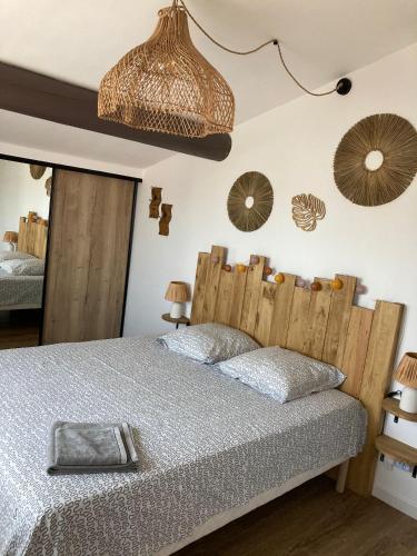 une chambre avec un lit avec une tête de lit en bois dans l'établissement Les Elles du Moulin Avec Piscine, à Vedène