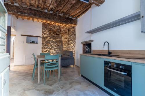 a kitchen with blue cabinets and a table and chairs at Vista sul Borgo in Monte San Savino