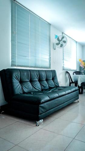 a black leather couch sitting in a living room at Aptos para tus vacaciones a 3 min del Parque del Cafe in Armenia