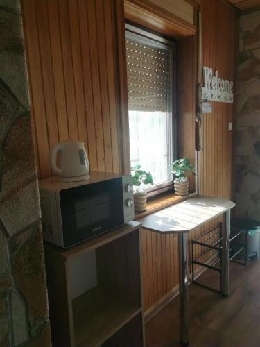 a room with a table with a microwave and a window at Villa Negra 1 in Balatonfenyves