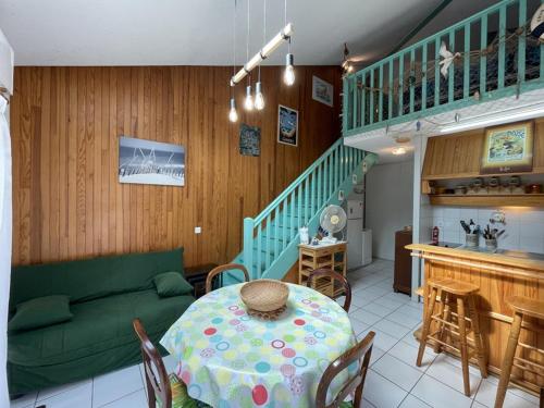 - un salon avec une table et un canapé vert dans l'établissement Charmant T2 mezzanine pour 4 pers. avec jardinet, proche du lac à Soustons - FR-1-379-72, à Soustons
