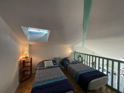 deux lits dans une chambre avec balcon dans l'établissement Charmant T2 mezzanine pour 4 pers. avec jardinet, proche du lac à Soustons - FR-1-379-72, à Soustons