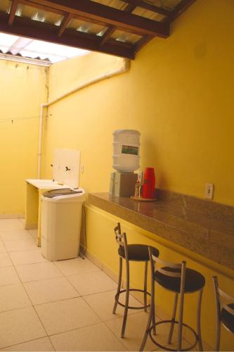 a kitchen with two chairs and a counter in a room at Recanto do Rey in Mucuri