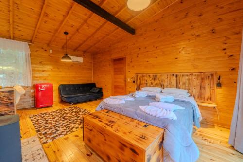a bedroom with a bed in a wooden room at Cascata dos Amores in Urubici
