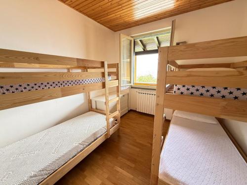 a room with two bunk beds and a window at Jasmine Demi- Cote apartement in Civenna