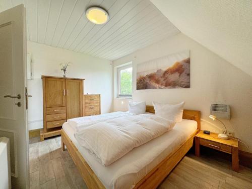 a bedroom with a large white bed and a window at Ferienwohnung in Tinnum auf Syt in Tinnum