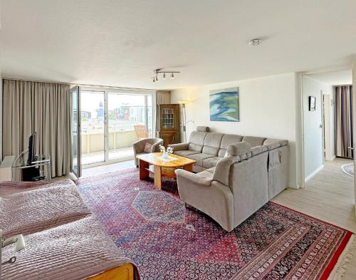 a living room with a couch and a tv at Dreizimmerwhg im Zentrum Westerland, Hanseatenhaus App 34 Balkon und Garage in Westerland (Sylt)