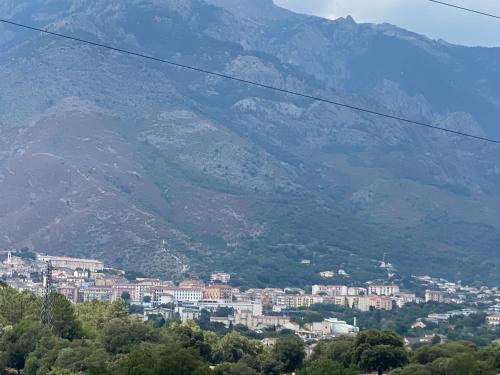 une vue d'une ville avec des montagnes en arrière-plan dans l'établissement Location très agréable T2 neuf corte, à Corte