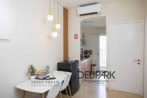 a room with a table and a kitchen with a door at Delipark Mall 2 Bedrooms 1 Bathroom 4-6 Pax Liberty Tower Level 9 in Medan