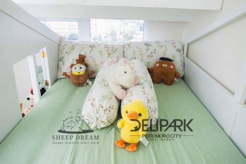 a bed with stuffed animals on it in a room at Delipark Mall 2 Bedrooms 1 Bathroom 4-6 Pax Liberty Tower Level 9 in Medan