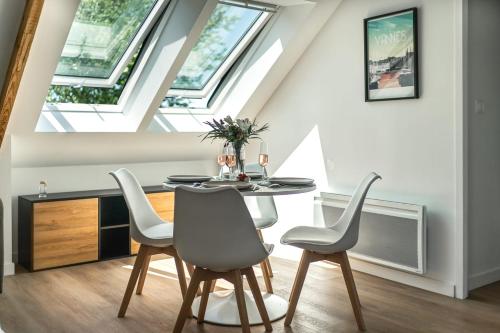 une salle à manger avec une table et quatre chaises dans l'établissement LOGODEN - Appartement TOUT CONFORT 2 Chambres, proximité gare, parking privé, à Vannes