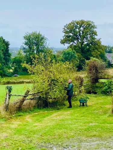 une femme debout à côté d'un buisson dans un champ dans l'établissement La Terrade, à Saint-Hilaire-La-Treille