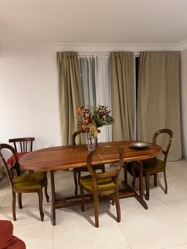 a wooden table with chairs and a vase of flowers on it at Casa Ludogiú in Scorrano