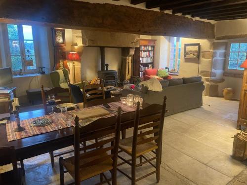 a living room with a table with chairs and a couch at La Terrade in Saint-Hilaire-La-Treille