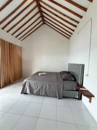 a bedroom with a bed and a wooden ceiling at Signature Scuba Gili Gede Dive and Stay in Gili Gede