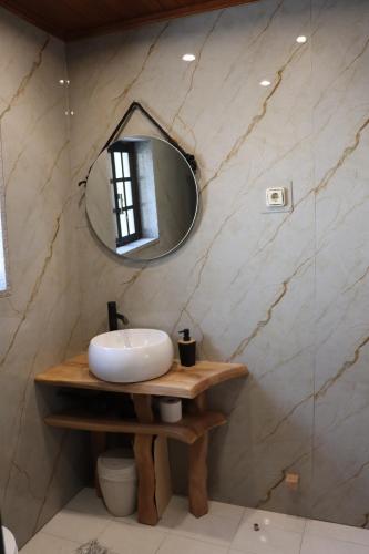 a bathroom with a sink and a mirror at Quartos e Apartamentos do Patrão in Sabugueiro