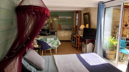 une chambre avec un lit et une cuisine avec une table dans l'établissement les 2 studios indépendants du clos de l'Ange, à Rieux