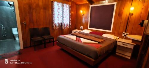 a bedroom with a bed and a flat screen tv at Nest 'N' Woods in Ooty