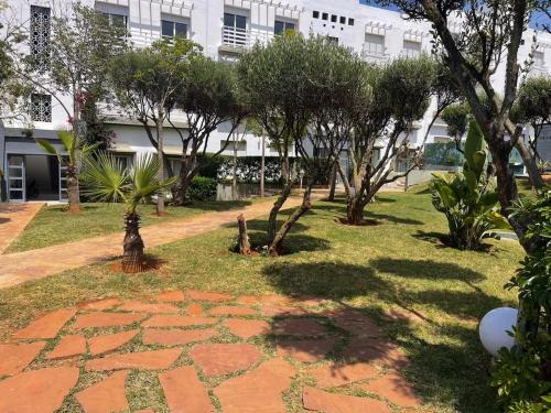 a garden with trees and a building in the background at Luxury Sea View in Tamaris
