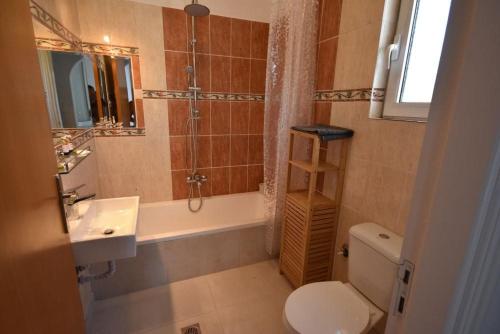 a bathroom with a toilet and a sink and a shower at Sofia Villa Near Faliraki in Kalithies